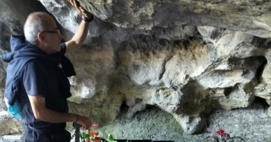 Lourdes, don Santo Borrelli e il gruppo di pellegrini calabresi in preghiera nella Grotta delle apparizioni